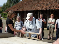 Museumspädagogin Astrid Weise erklärt den Besuchern, wie die Ziegel mit einem Streichrahmen hergestellt werden. Foto: LWL